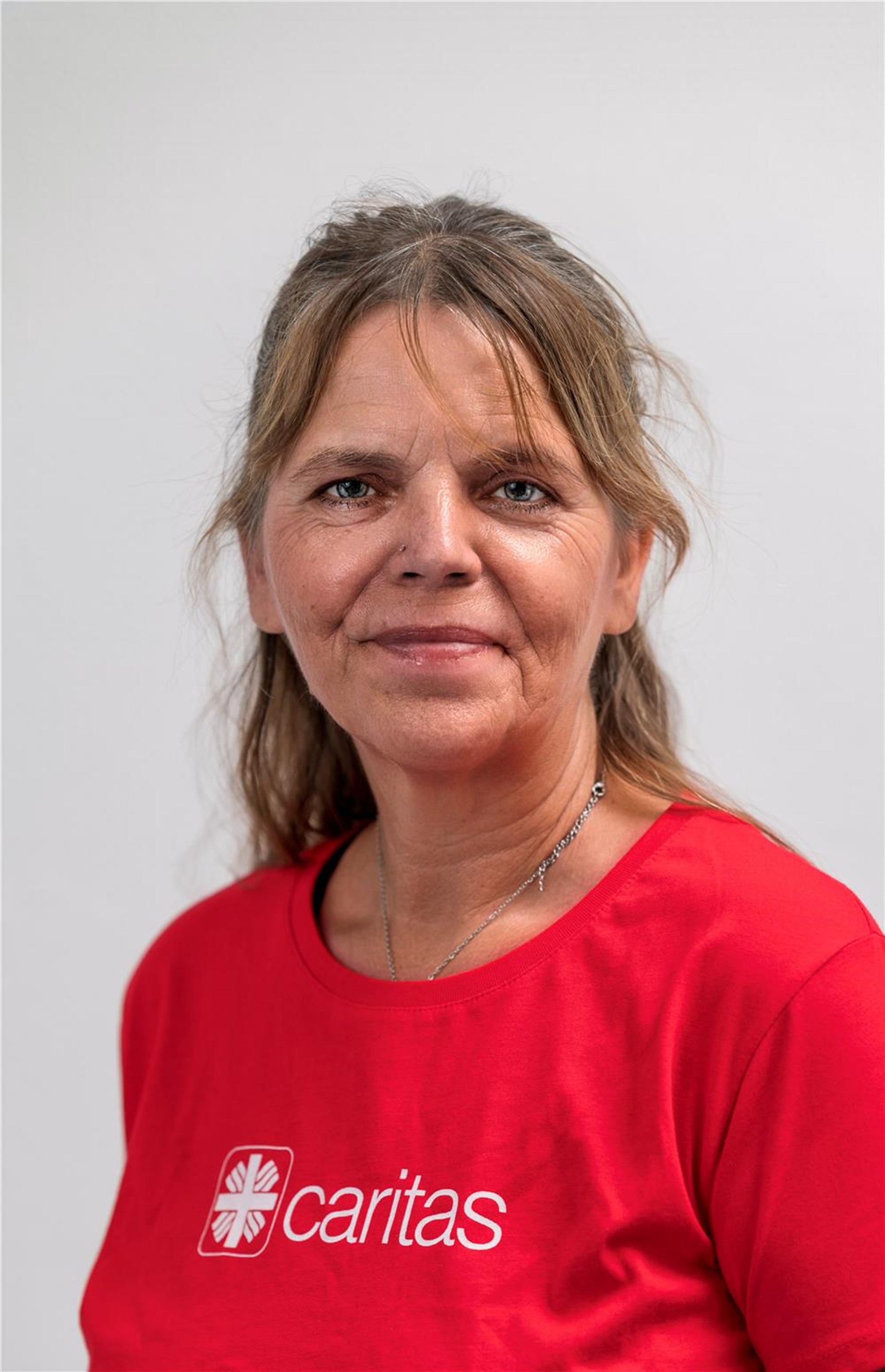 Portrait von Frau Sabine Hesche im roten Caritas-T-Shirt.